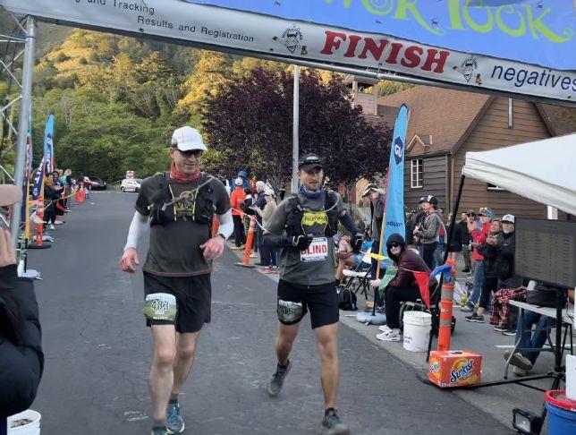 Will Barkan and his guide cross the finish line of a running event
